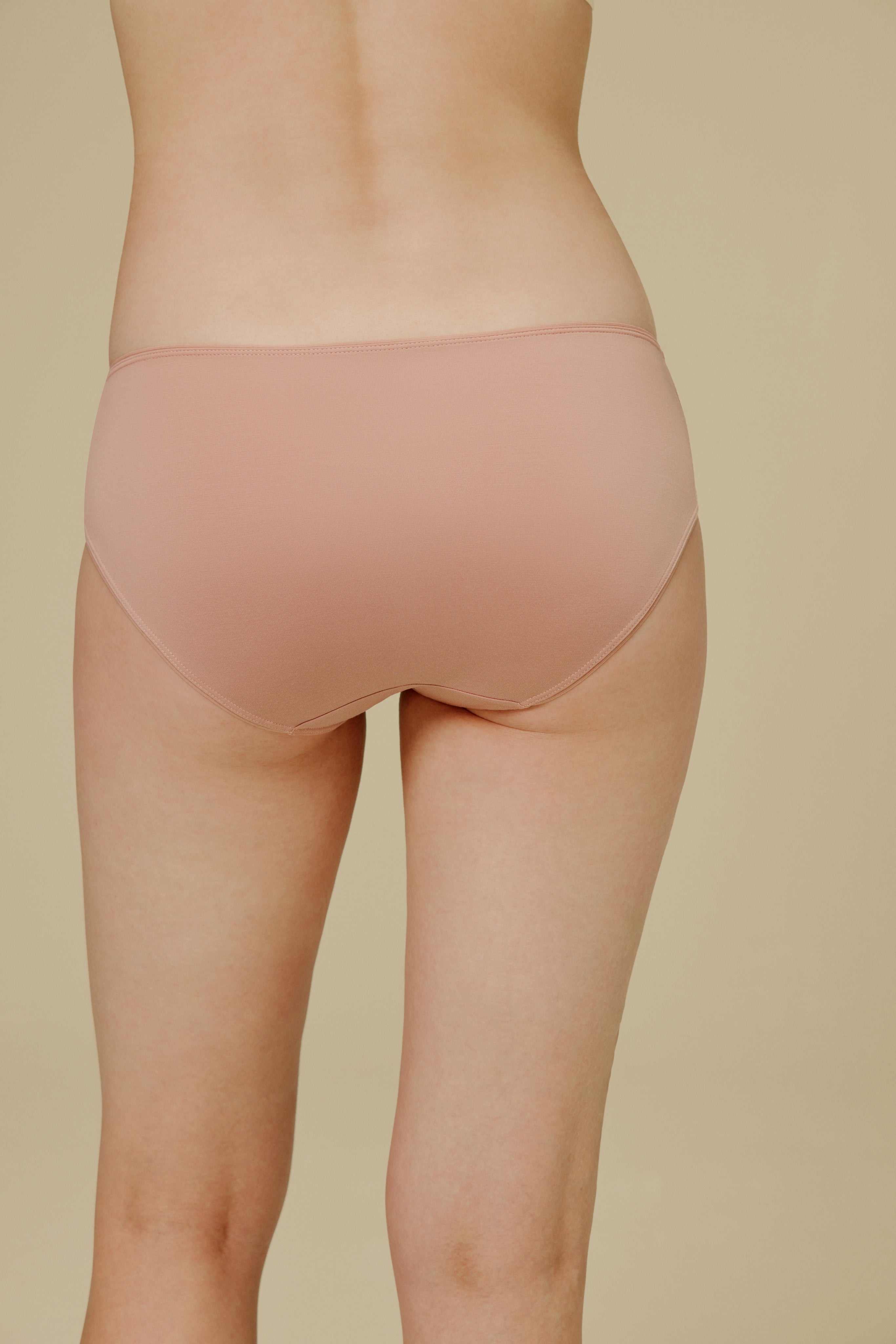 Back of woman in light pink underwear