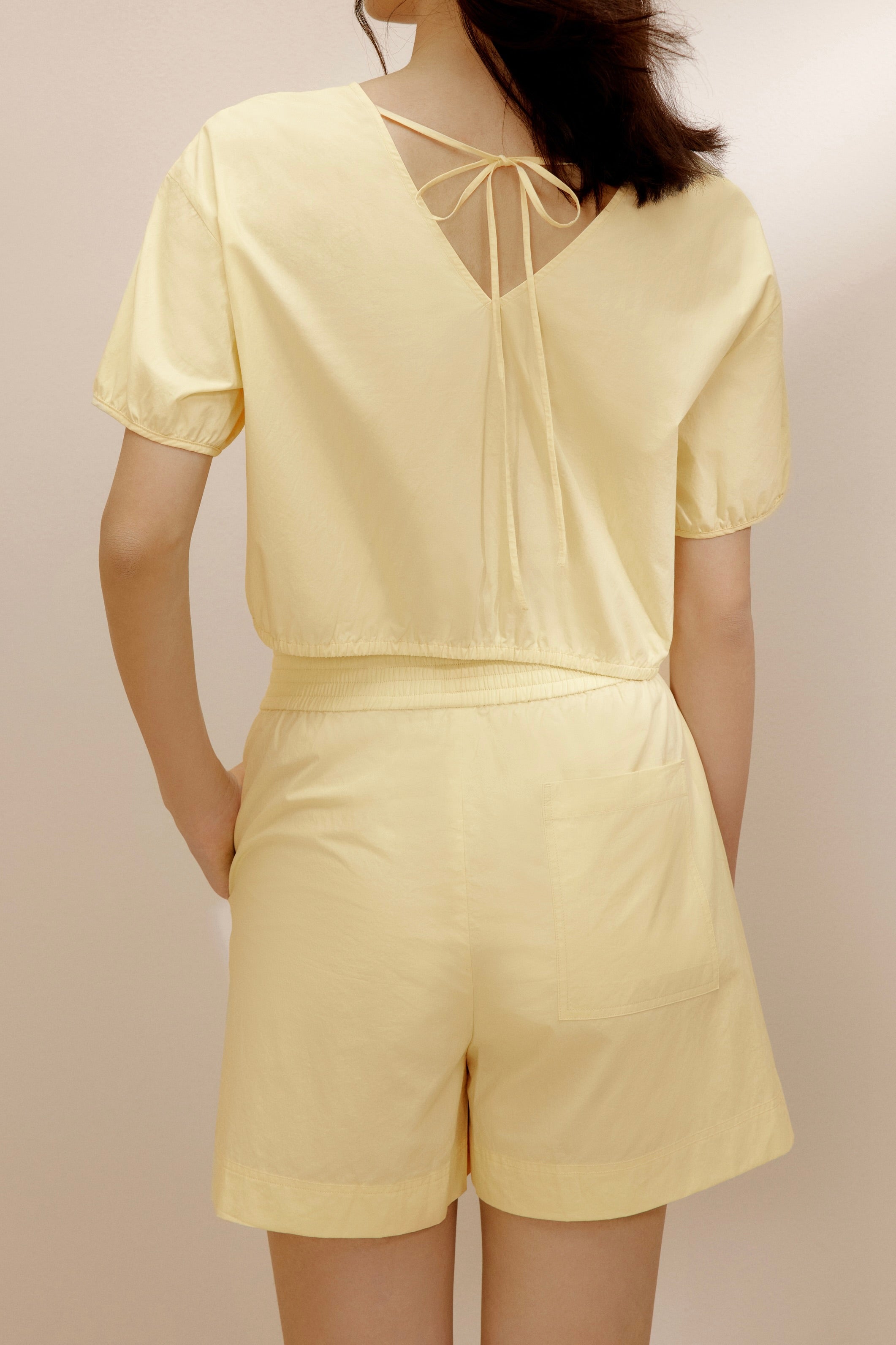 Back view of woman wearing yellow top.
