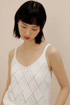 Woman wearing cream crochet tank top.