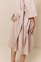 close up of woman in light pink long pajama robe