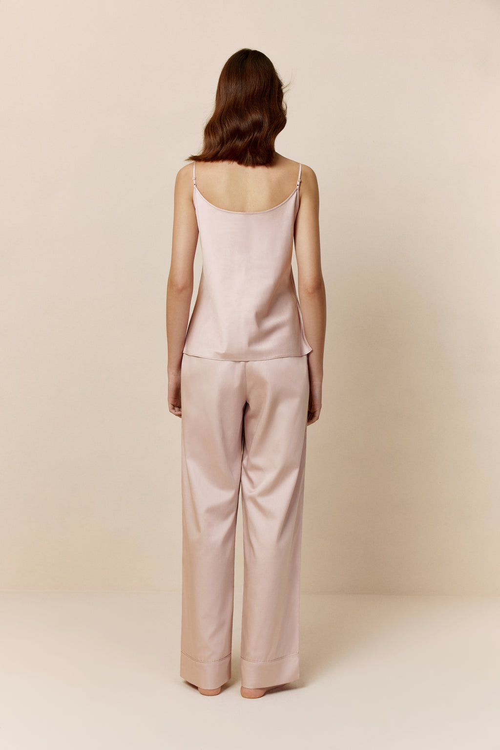 back of woman in light pink camisole and pants