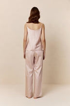 back of woman in light pink camisole and pants