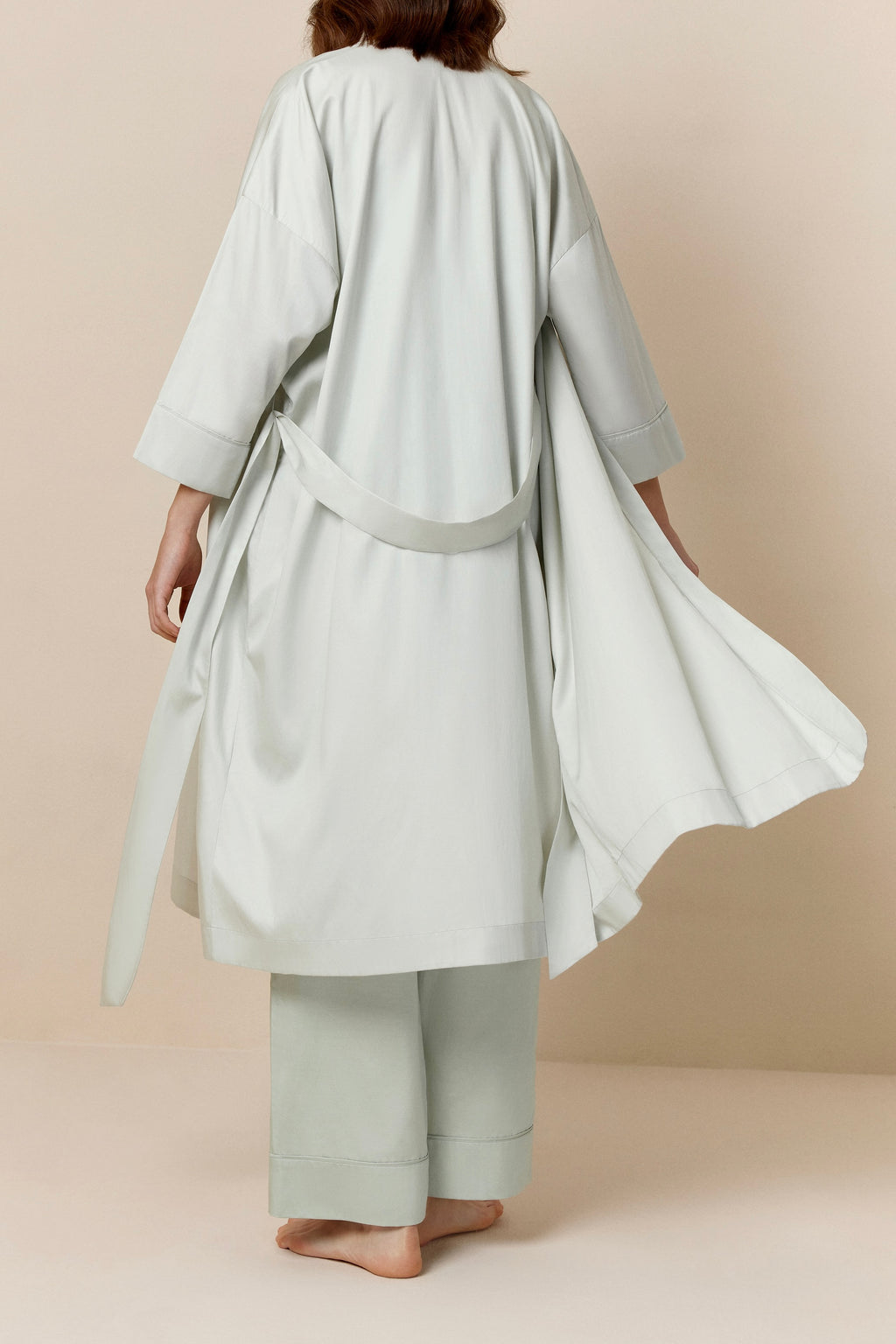 back of woman in blue blush long pajama robe and pajama set