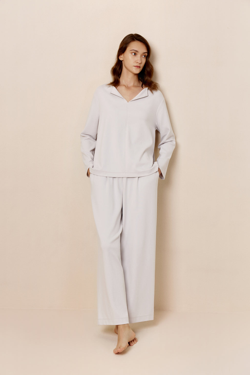Front view of woman in light gray top and pants.
