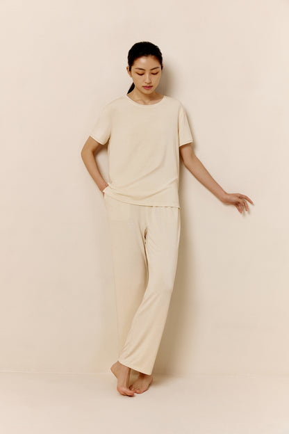 Woman wearing off-white short sleeve pajama shirt and matching pants