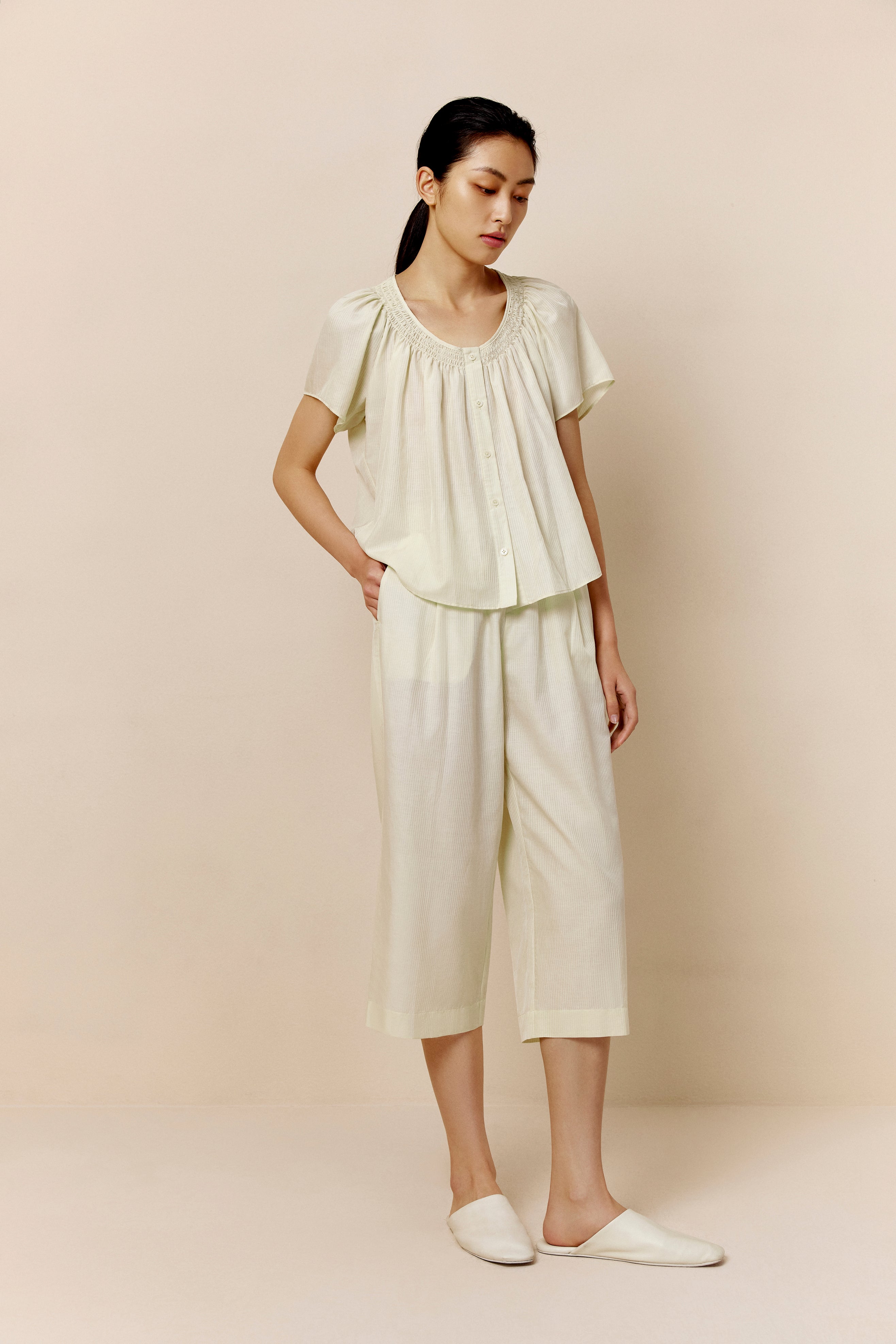 Woman wearing off-white short sleeve top and cropped pajama pants