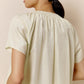 A woman wears off-white pajama top.