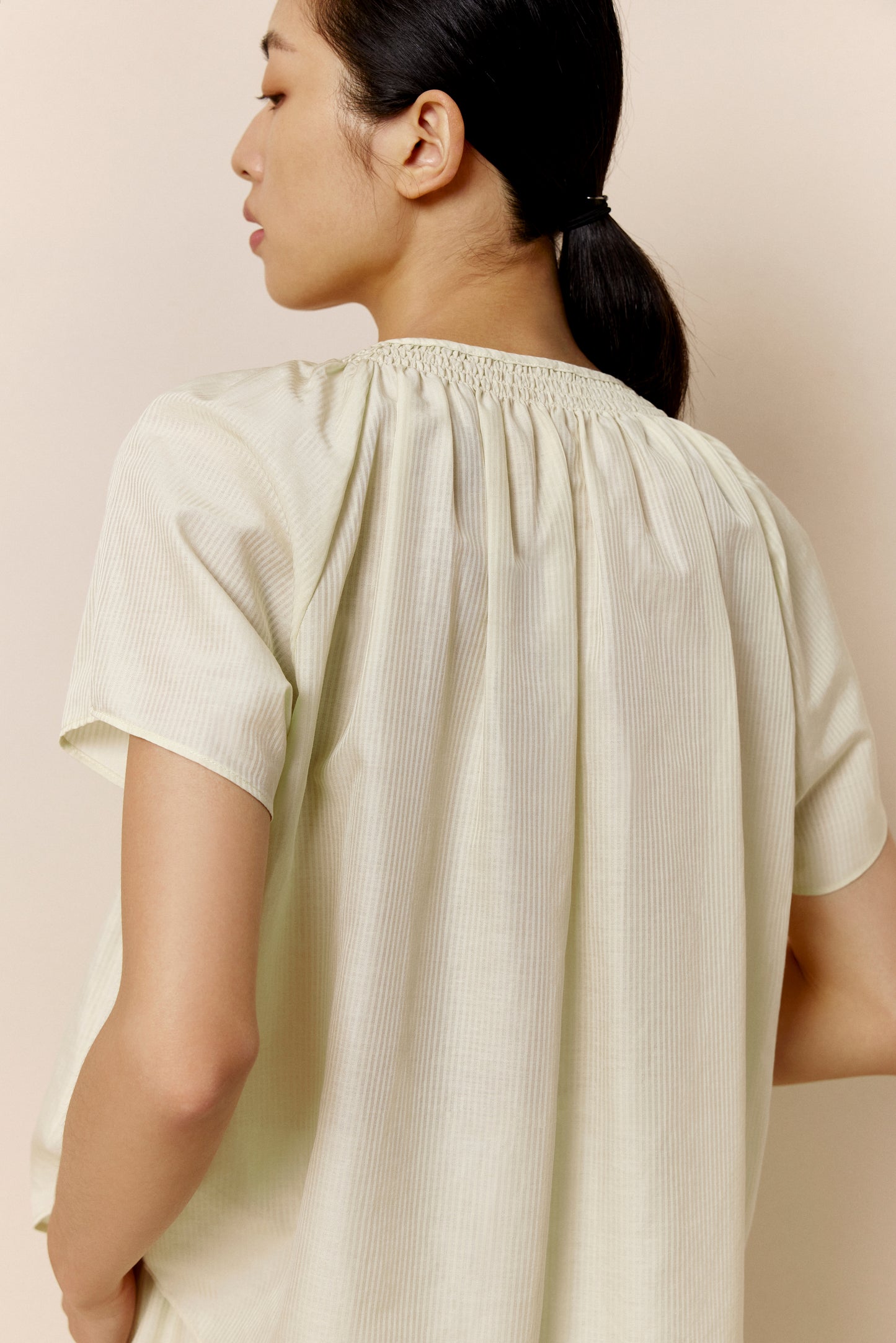 A woman wears off-white pajama top.