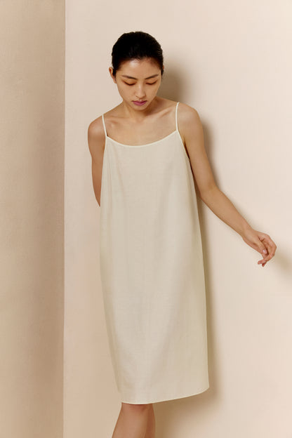 Woman wearing off-white spaghetti strap pajama dress