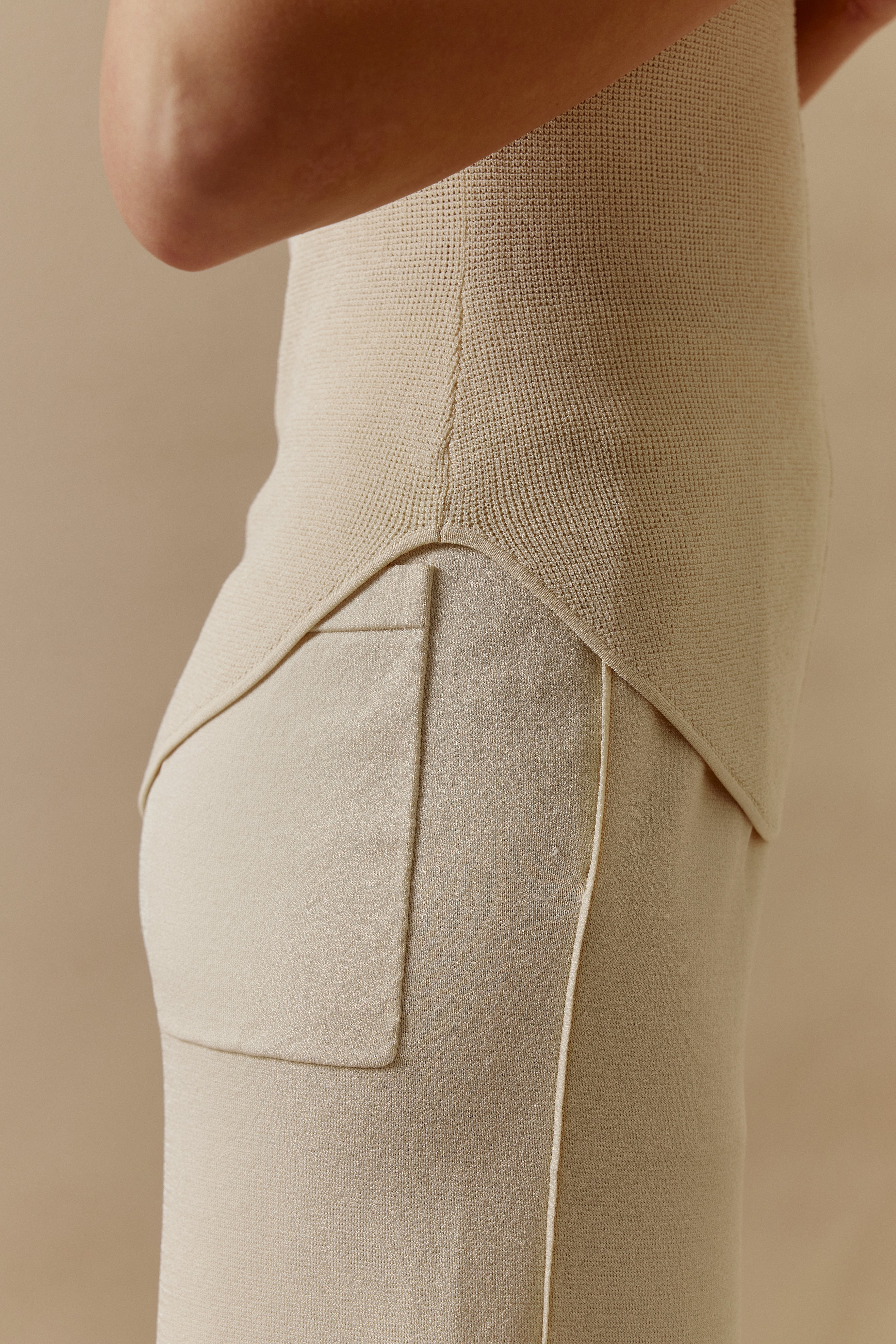 Side view of woman in off-white short-sleeved shirt