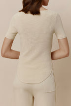 Back view of woman in off-white short-sleeved shirt