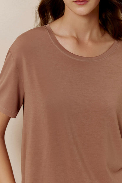 Close up of woman wearing dusty rose short sleeve pajama shirt