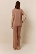 Back of woman wearing dusty rose short sleeve pajama shirt and matching pants