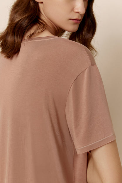 Close-up of shoulder of woman wearing dusty rose short sleeve pajama shirt