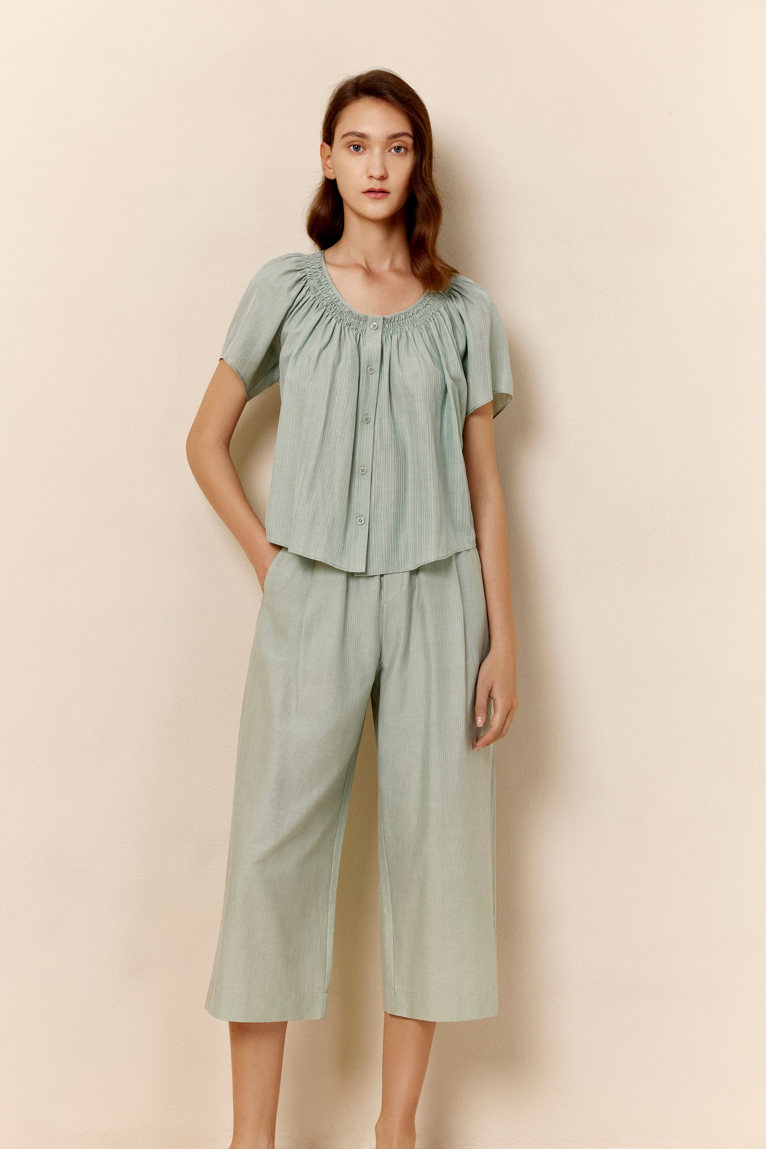 Woman wearing seafoam green top and cropped pajama pants
