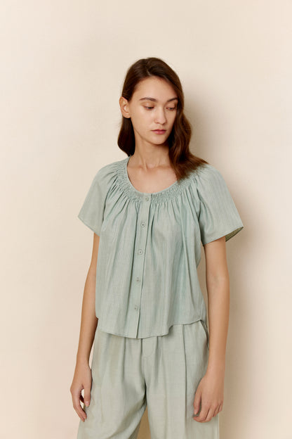 A woman wears teal pajamas.