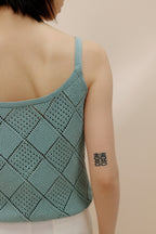Back view of woman wearing blue crochet tank top.