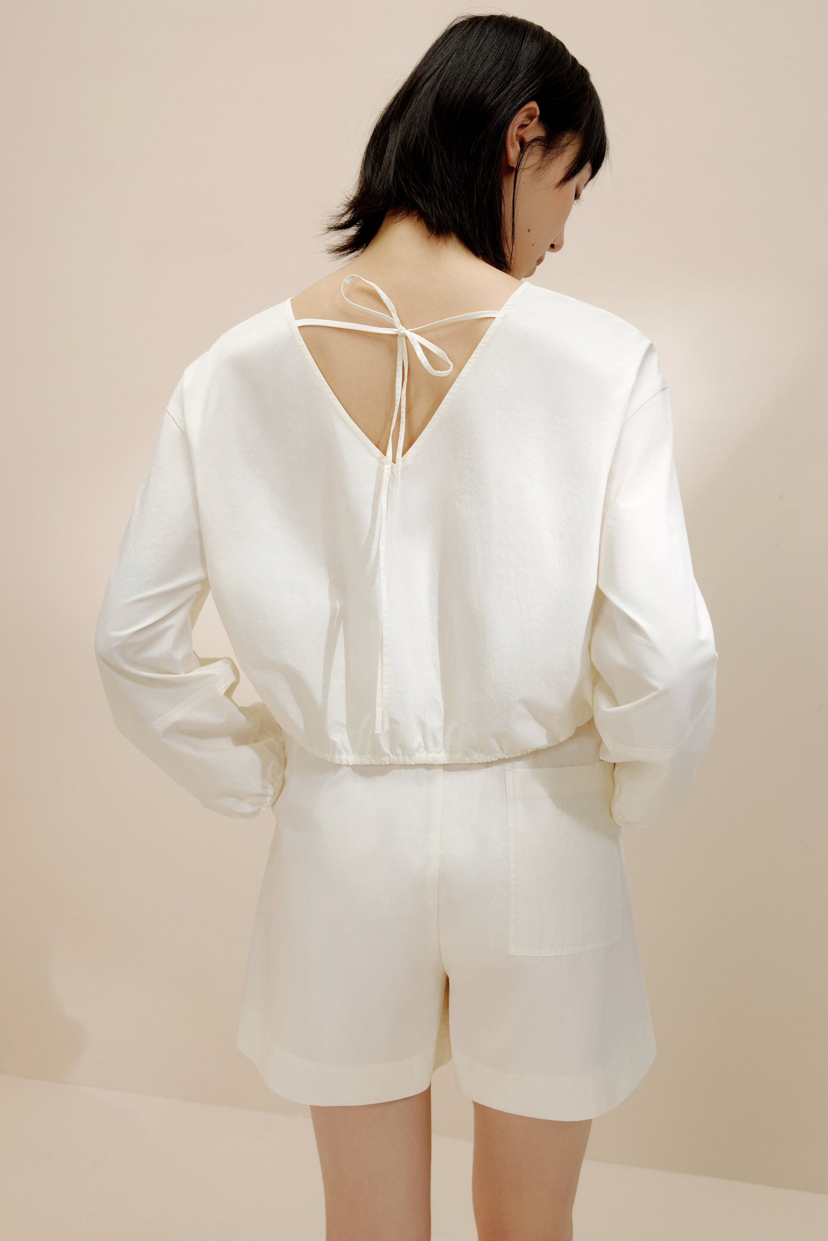 Back view of woman wearing white top.