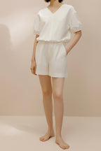 Front view of model wearing white top and white shorts.