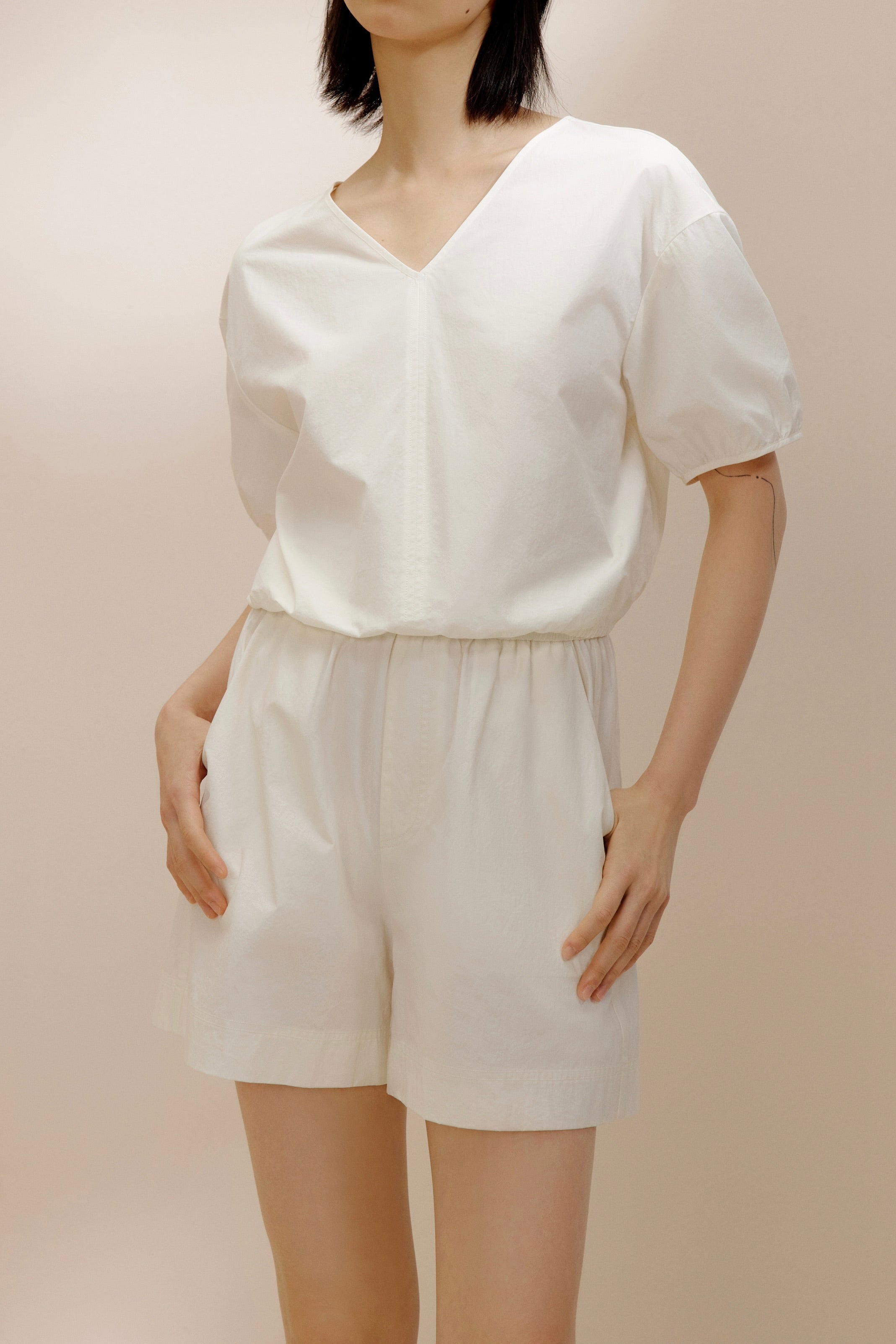 Woman wearing white V-neck top