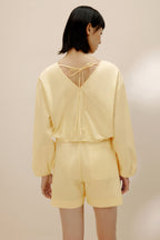 Back view of woman in yellow top and yellow shorts.