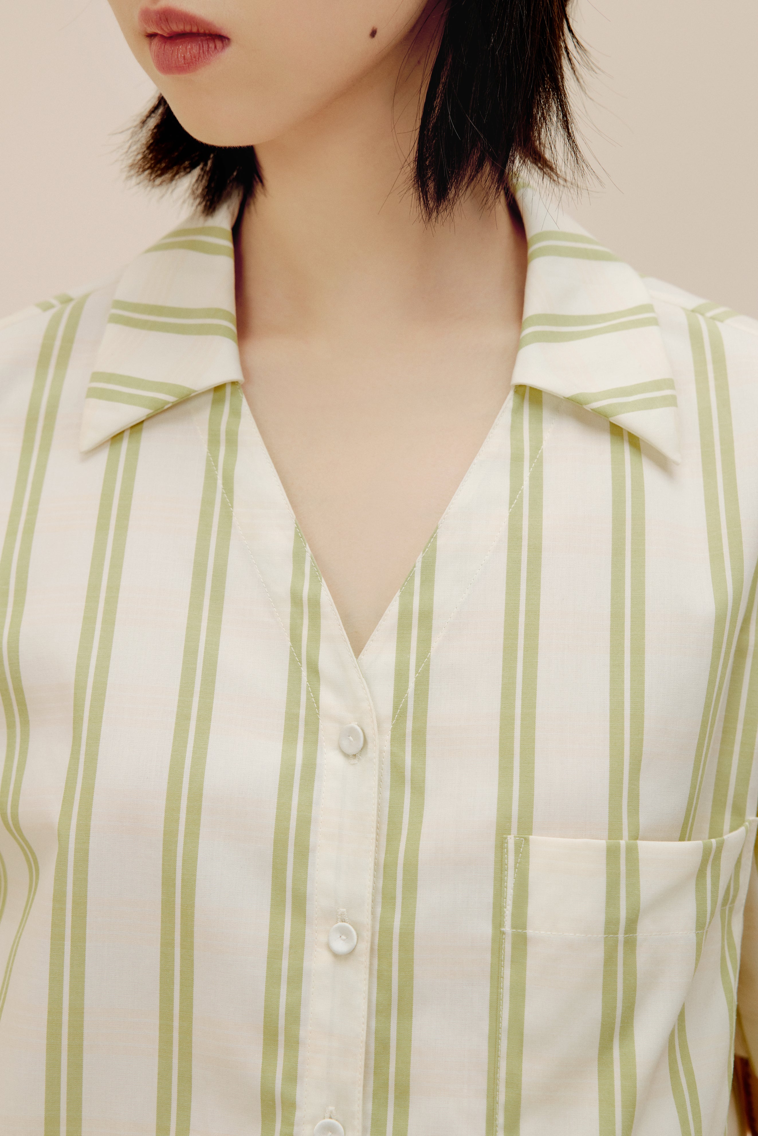 Closeup of woman wearing white and green striped pajama shirt