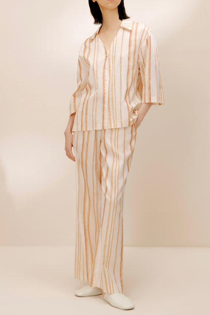 Woman wearing striped top with matching striped pants.