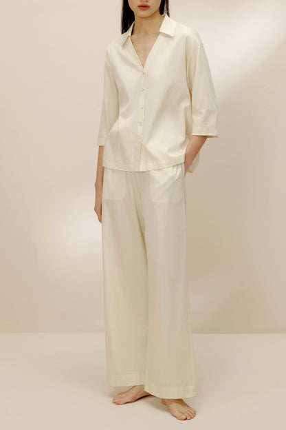 Woman wearing ivory top with matching pants.