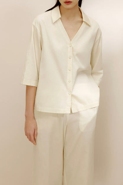 Woman wearing ivory top.