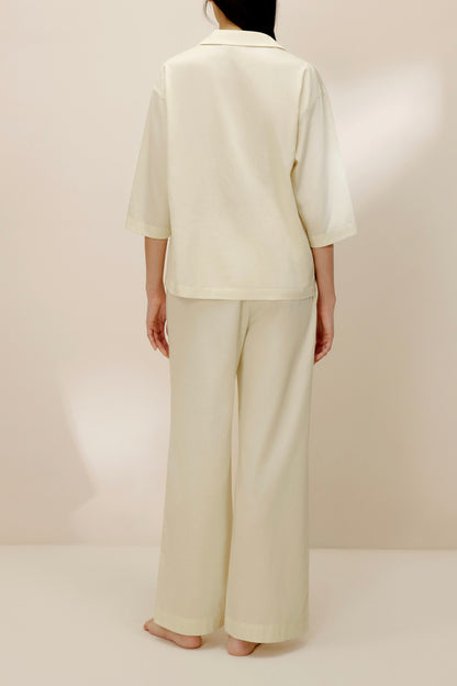 Back view of woman wearing ivory top.