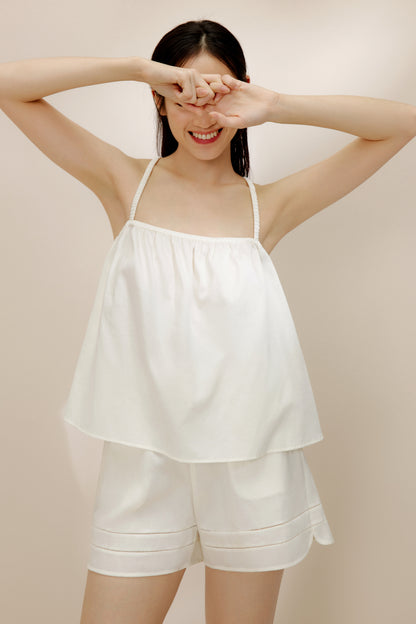 Woman wearing white pajama tank top and matching shorts