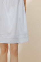 Close-up view of light blue pajama dress hem.