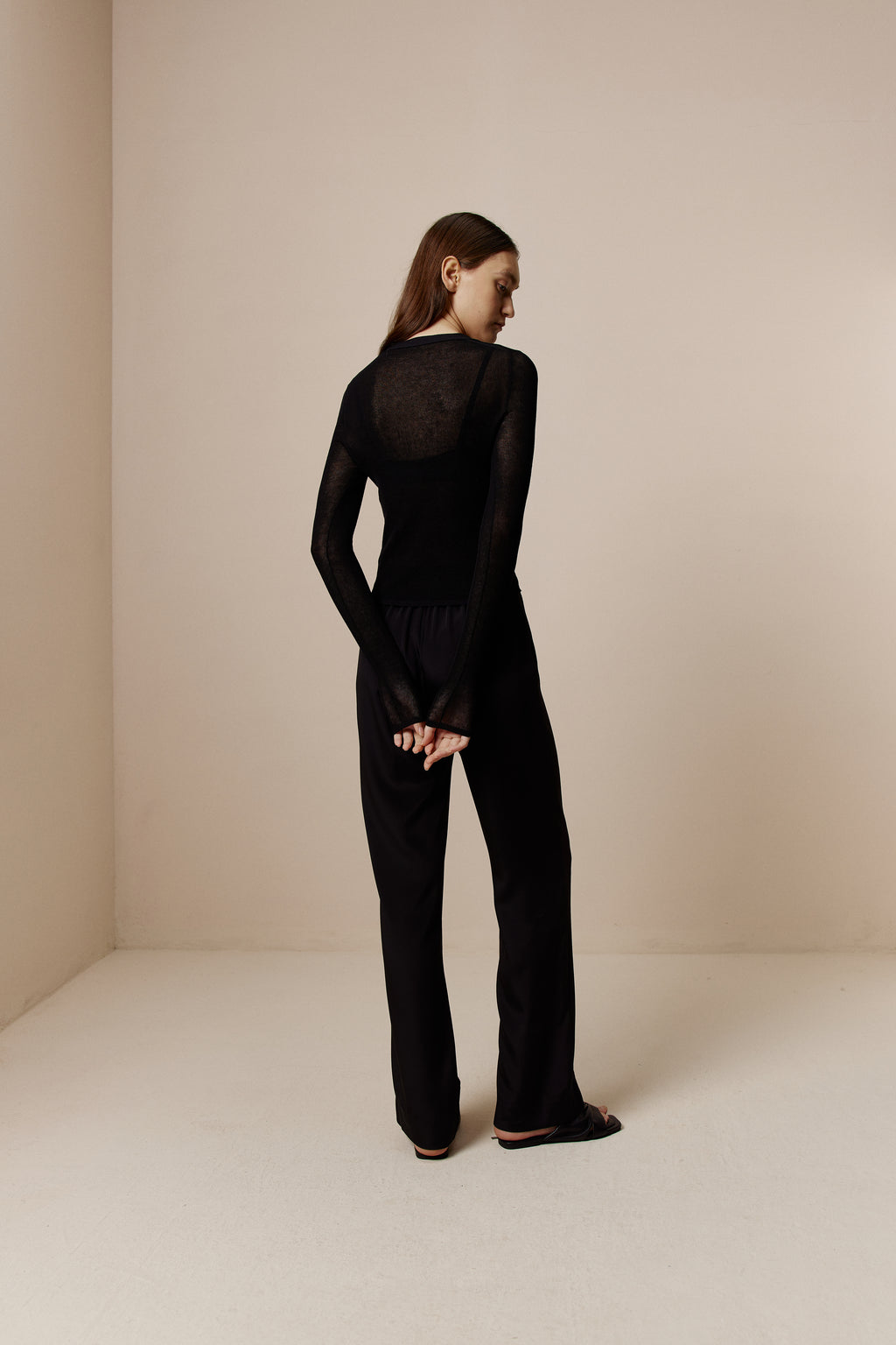 back of women in black Knitted Cardigan and black pants