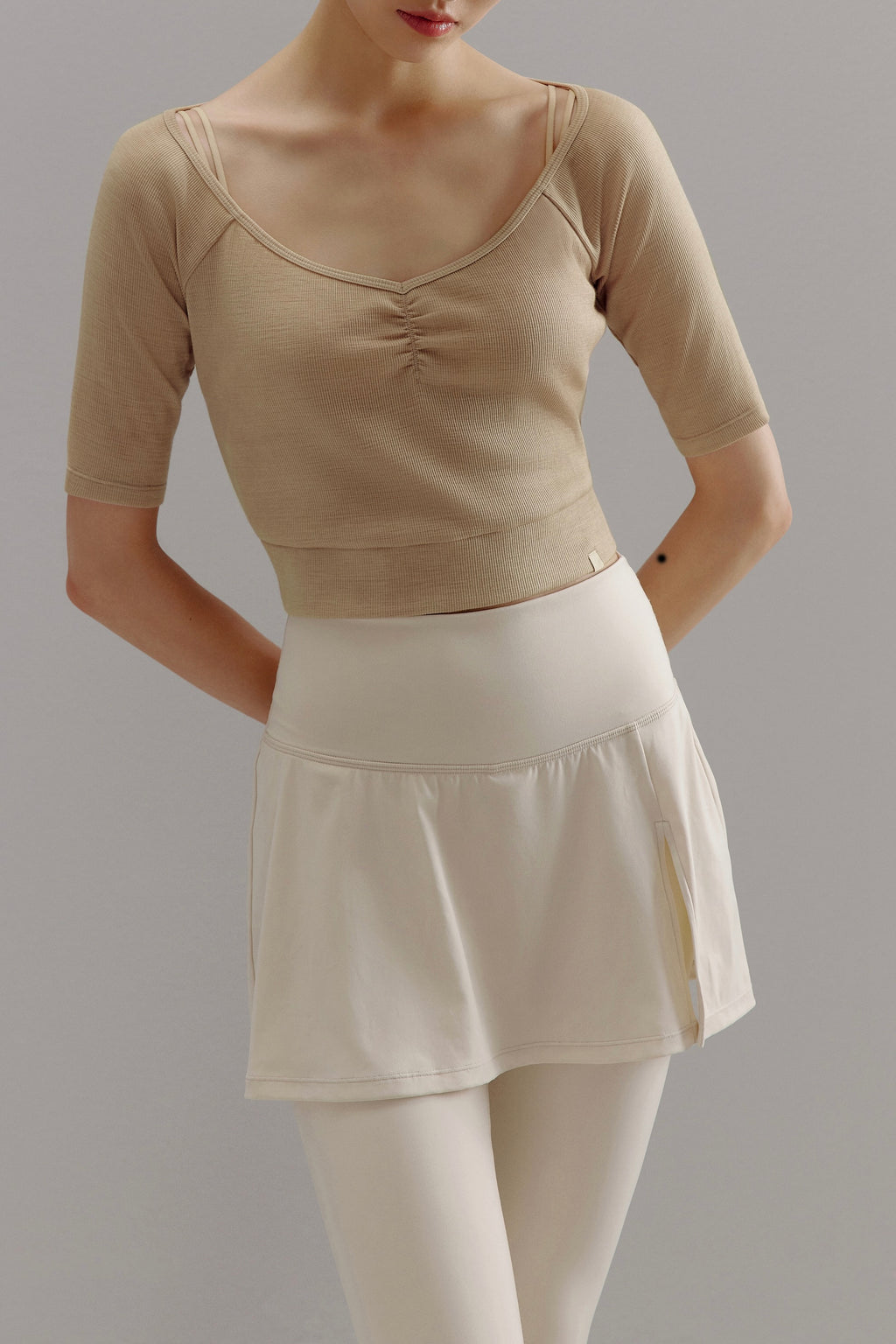 Woman wearing beige V-neck sweater.