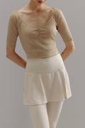 Woman wearing beige V-neck sweater.