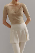 Woman wearing beige V-neck sweater.