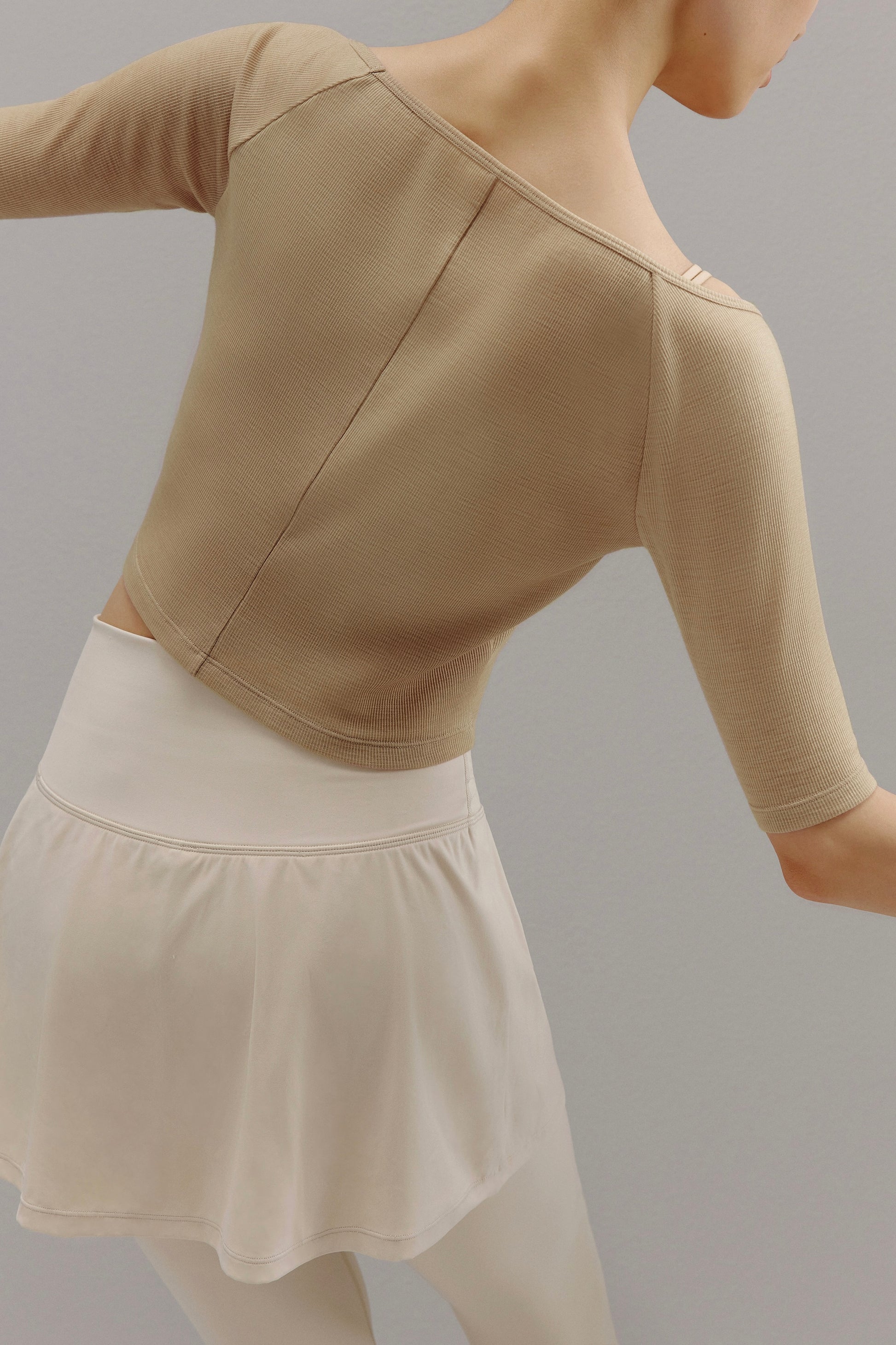 Back view of woman wearing beige sweater.