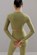 Back view of woman wearing green cropped top and matching leggings.