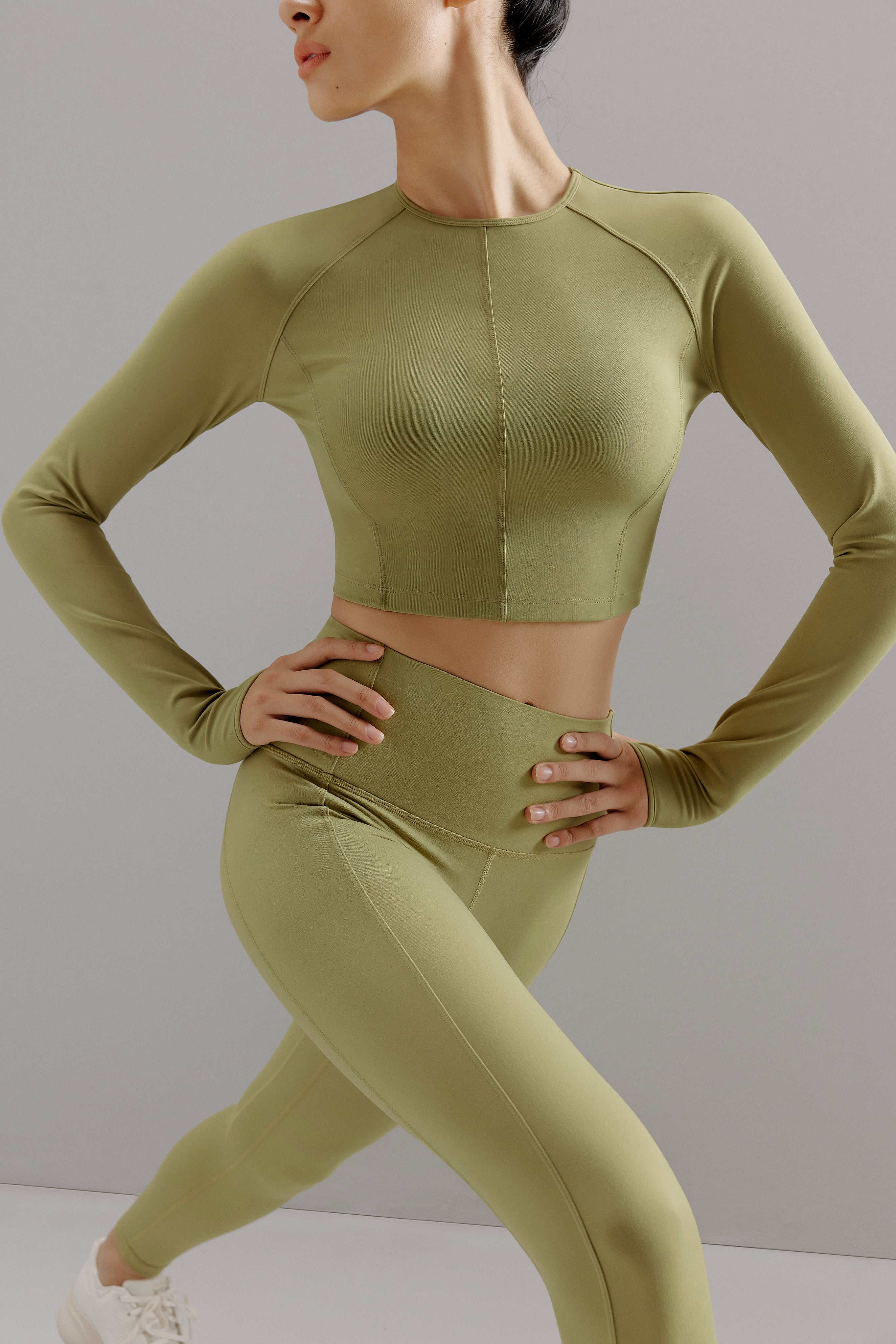 Woman wearing cropped green top with matching leggings.