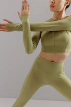 Woman wearing light green cropped top with matching leggings.