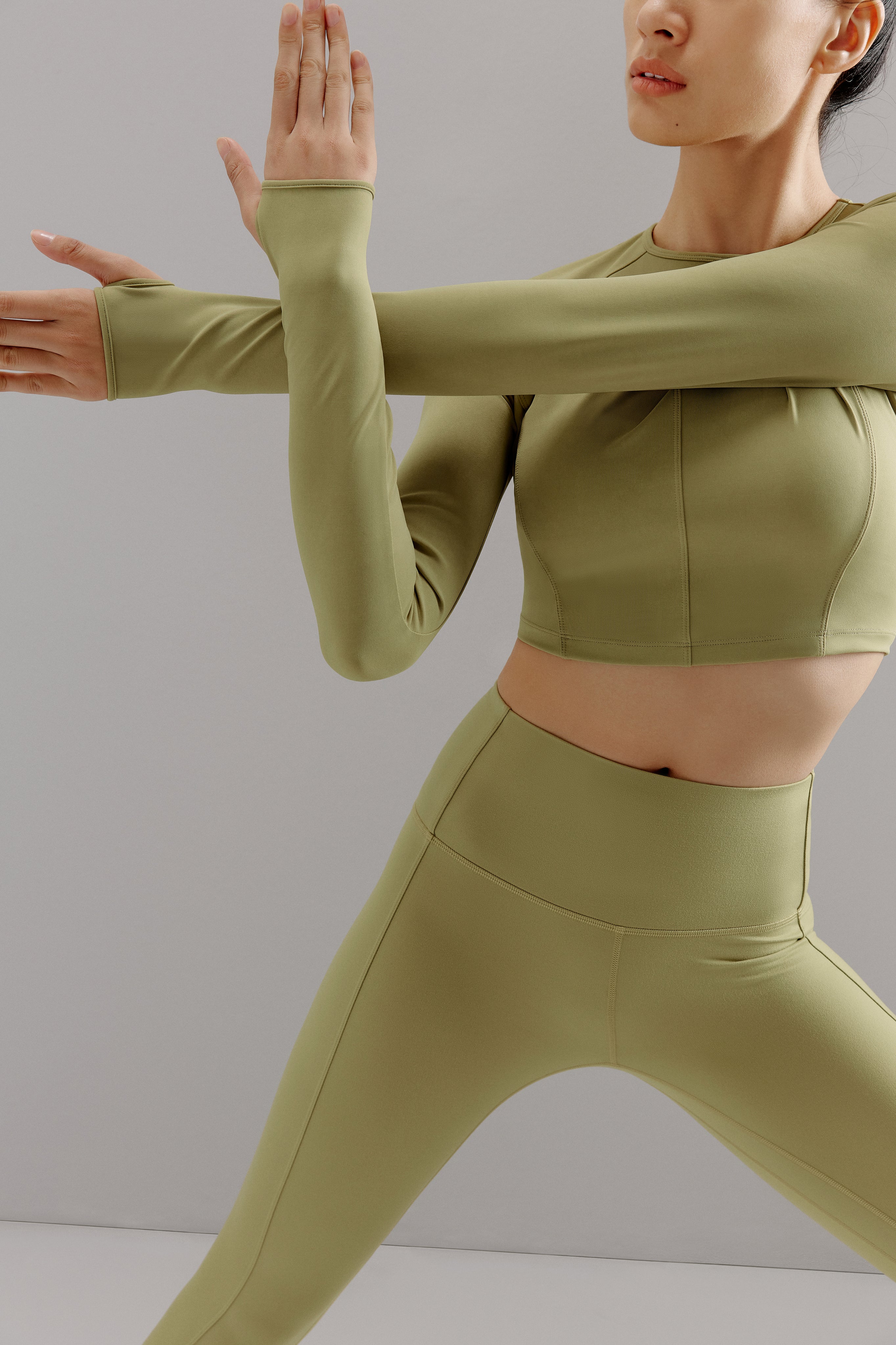 Woman wearing light green cropped top with matching leggings.