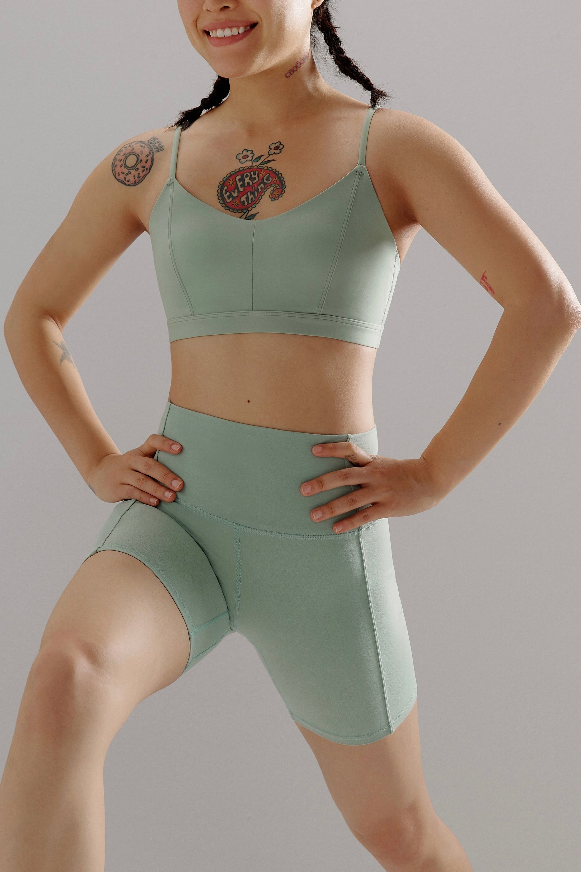 Woman in a lunge wearing aqua sports bra and matching biker shorts