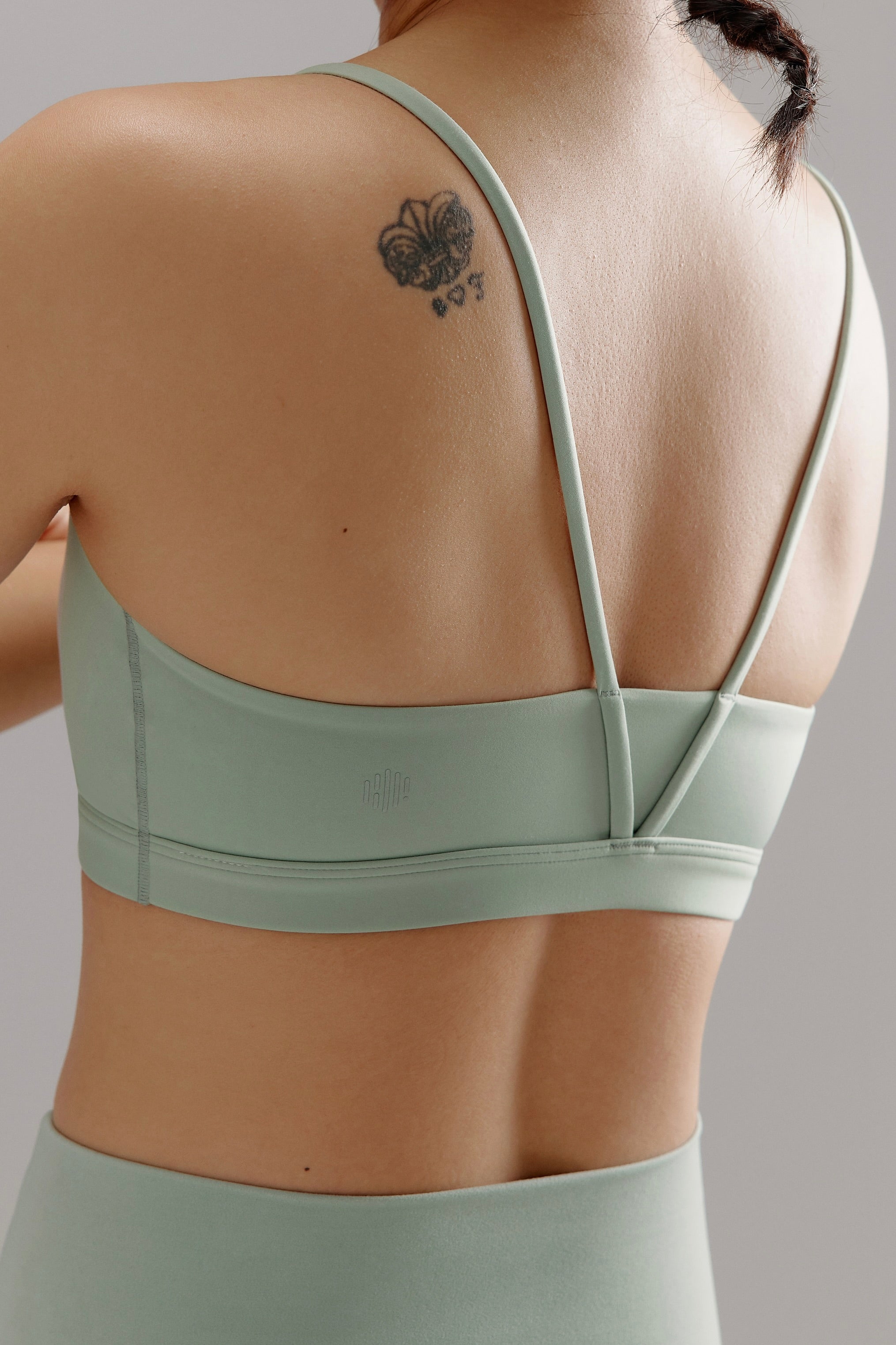 Back of woman wearing aqua sports bra and matching biker shorts