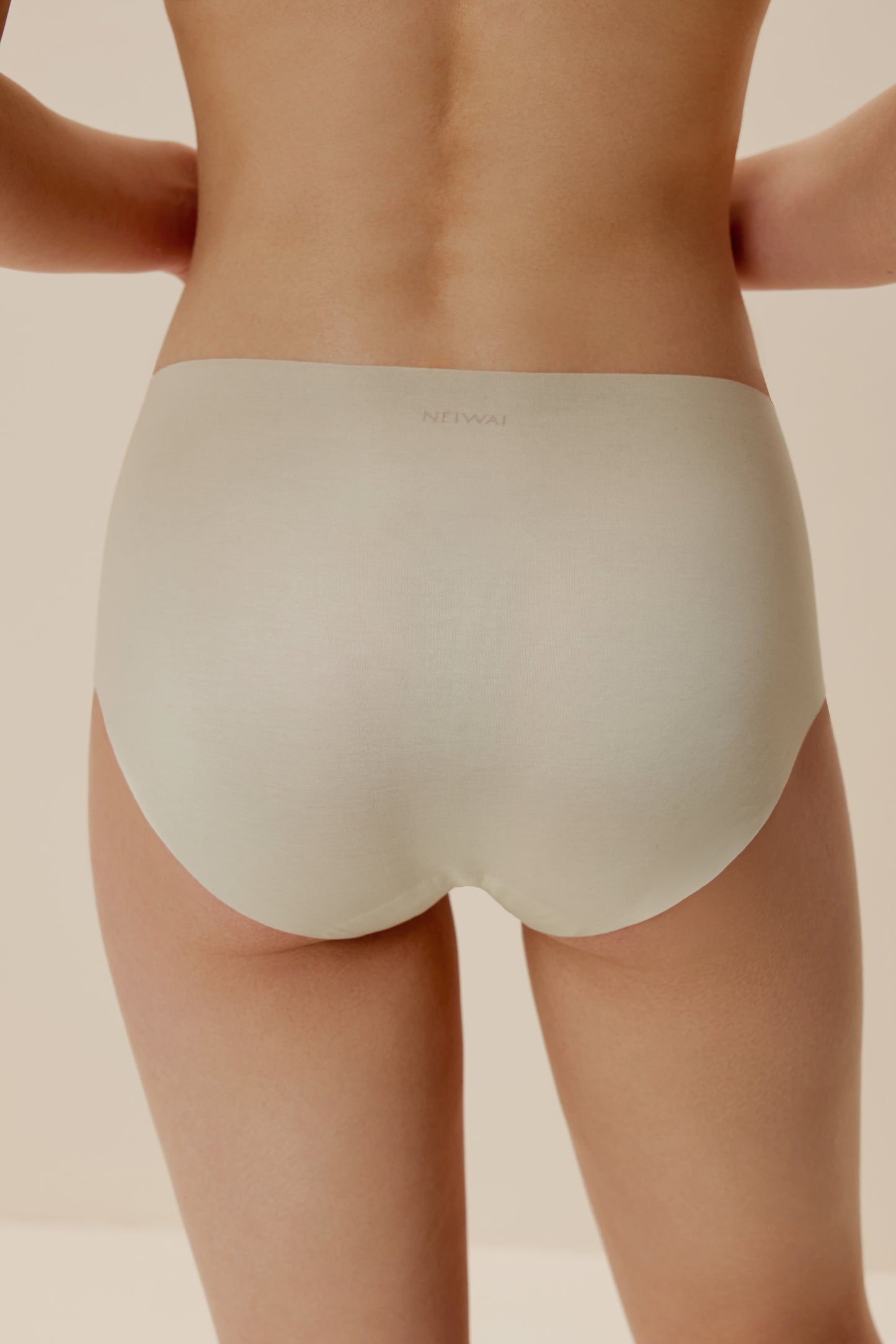 back of woman in off white brief