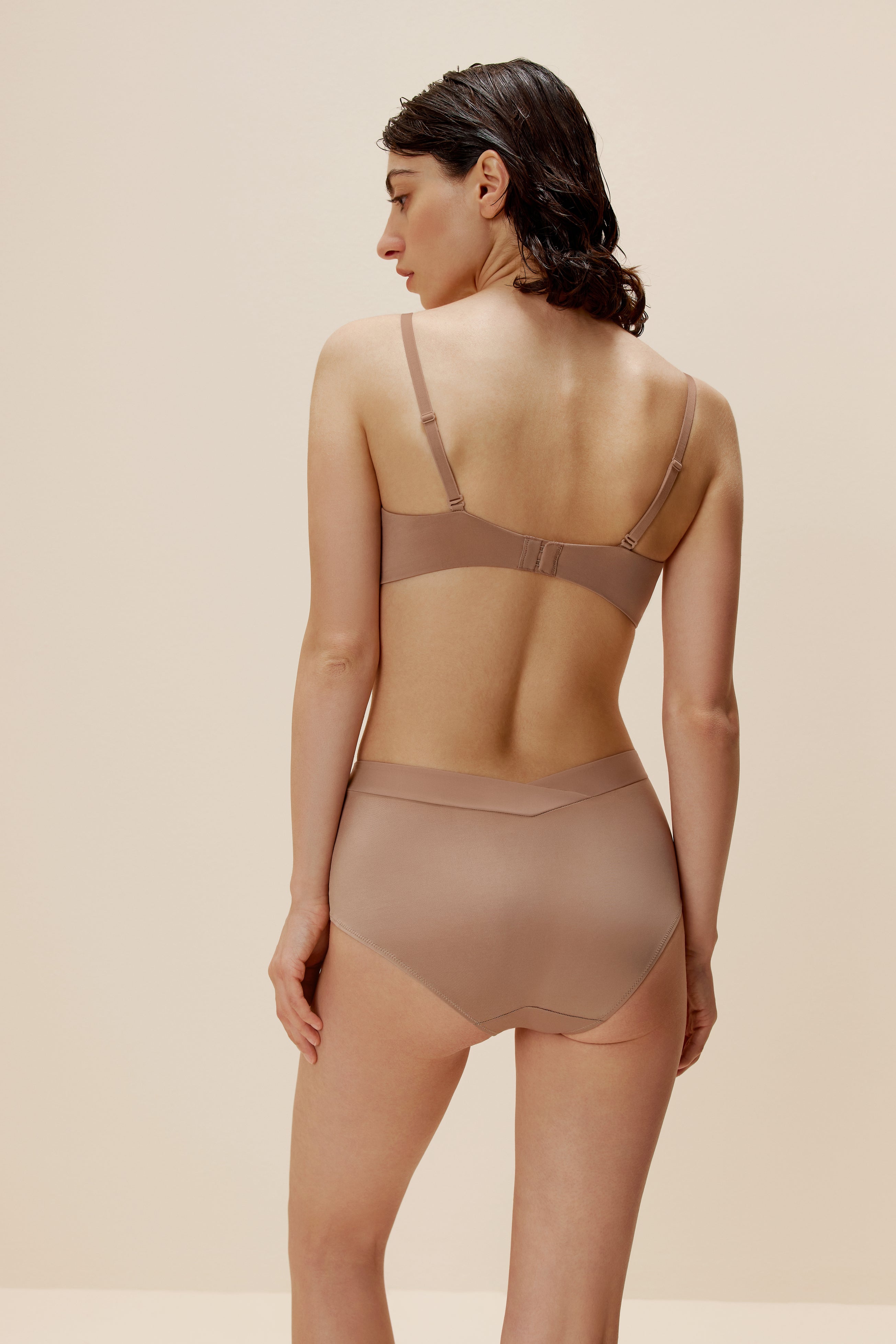 back of woman in tan bra and brief