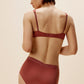 back of woman in maroon bra and brief