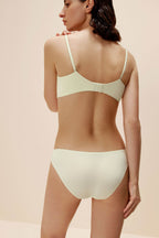 back of woman in light yellow bra and brief