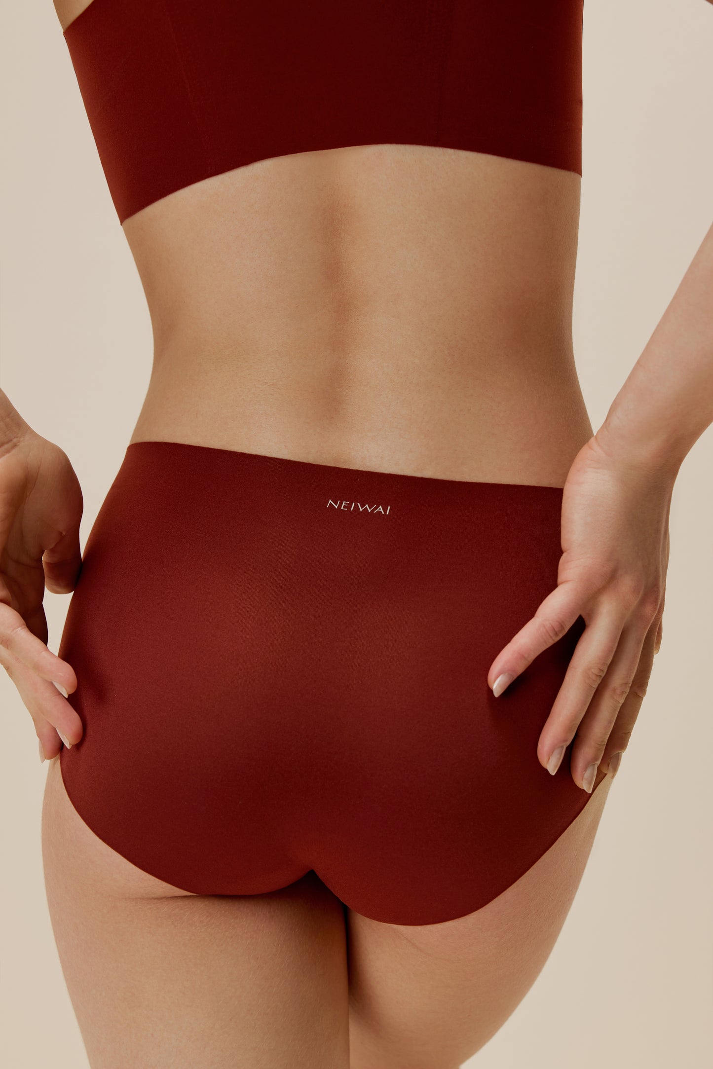 back of woman in maroon brief with NEIWAI printed on the waist
