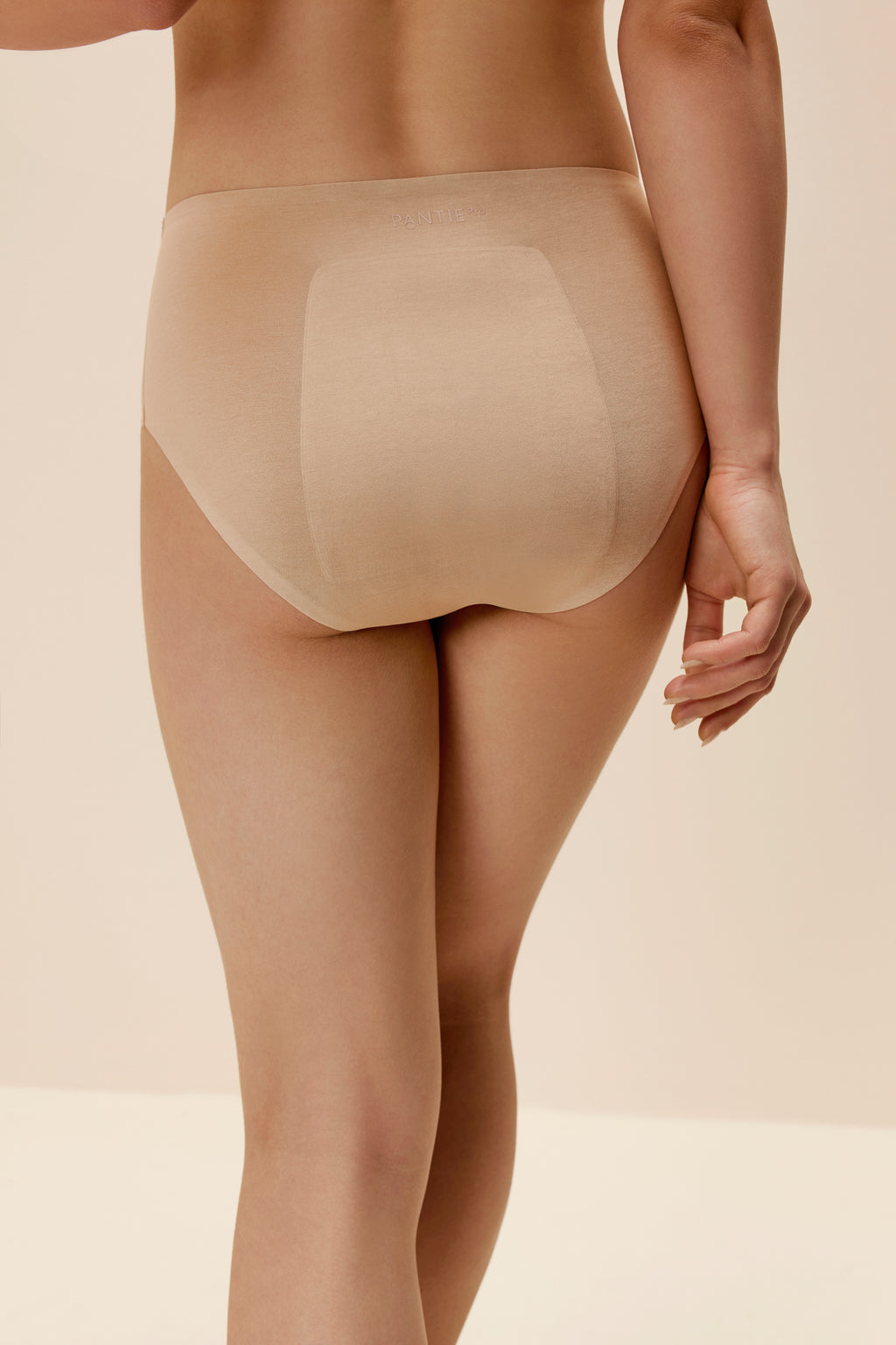 back of woman in tan underwear