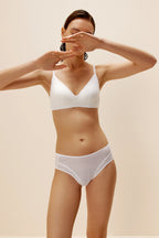 A woman wears a white bra and brief.